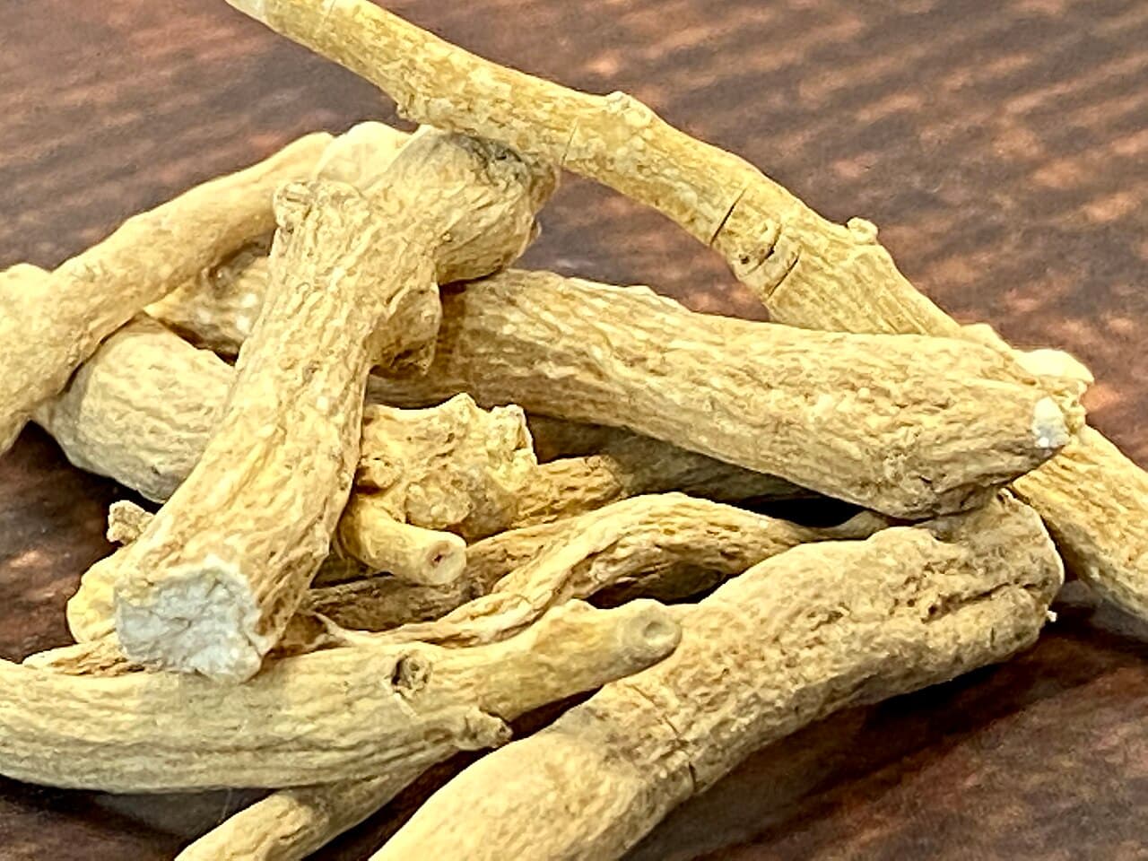 Dried ashwagandha roots on a dark wooden surface