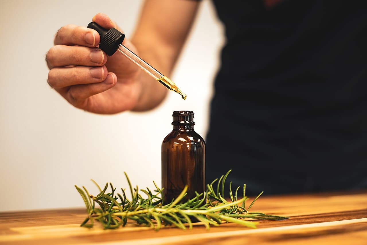 Herbal oil being drawn from an amber dropper bottle